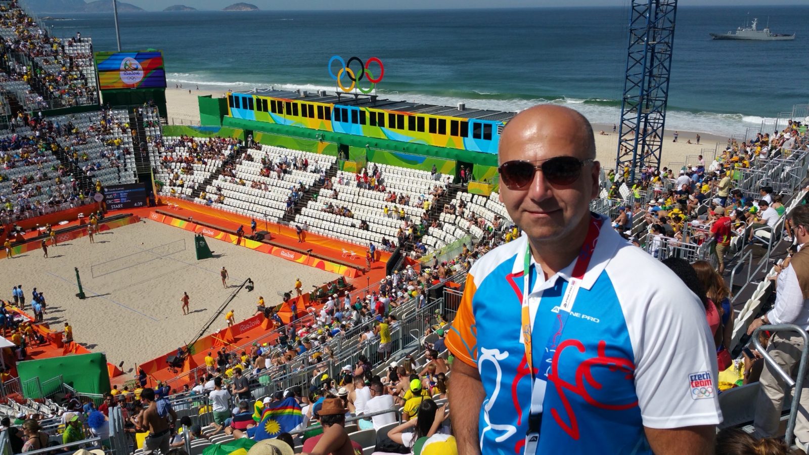 Ein Mann auf einer Tribüne über einem Beachvolleyballfeld